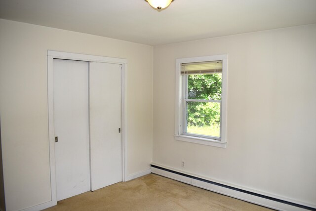 25 Ariel St, Lincoln, ME 04457 - unfurnished bedroom with a baseboard radiator, light carpet, and a closet