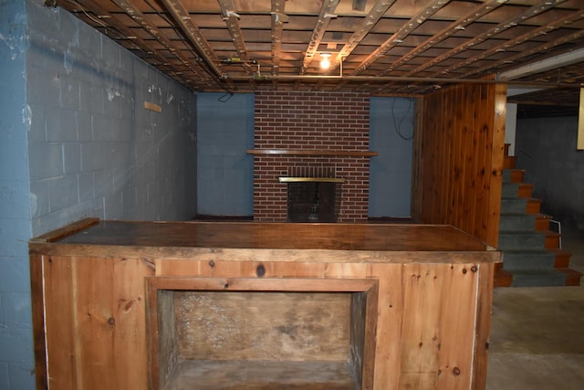 25 Ariel St, Lincoln, ME 04457 - finished basement featuring a brick fireplace, stairs, a bar, and concrete block wall