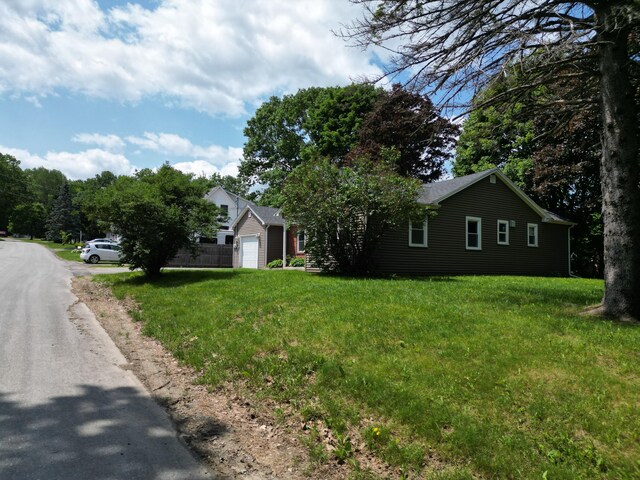 25 Ariel St, Lincoln, ME 04457 - view of front facade featuring an attached garage and a front yard