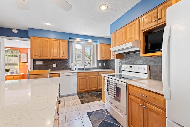 25 Harding St, Biddeford, ME 04005 - kitchen featuring white appliances, under cabinet range hood, backsplash, light tile patterned floors, and light stone counters