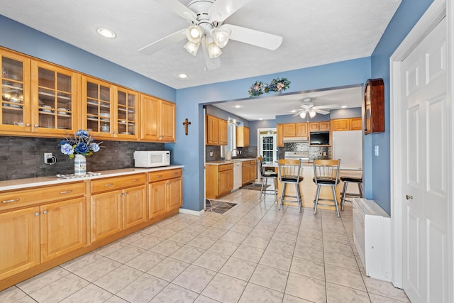 25 Harding St, Biddeford, ME 04005 - kitchen with white microwave, a ceiling fan, backsplash, a kitchen breakfast bar, and recessed lighting