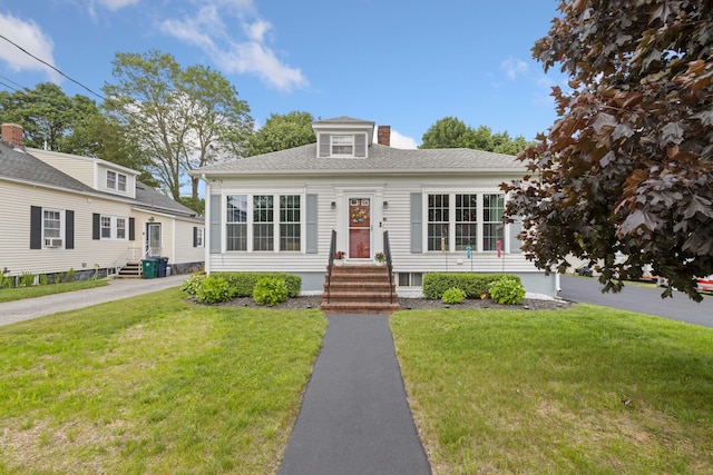 25 Harding St, Biddeford, ME 04005 - view of front of property with entry steps, a front yard, a chimney, and a shingled roof