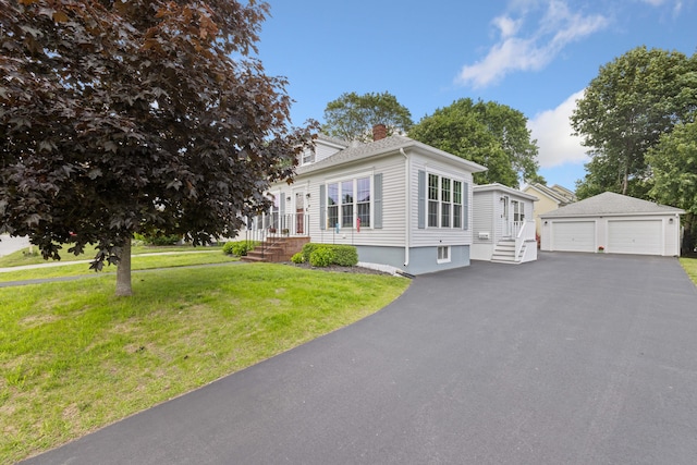 25 Harding St, Biddeford, ME 04005 - view of front of house featuring a garage, a chimney, an outdoor structure, and a front yard