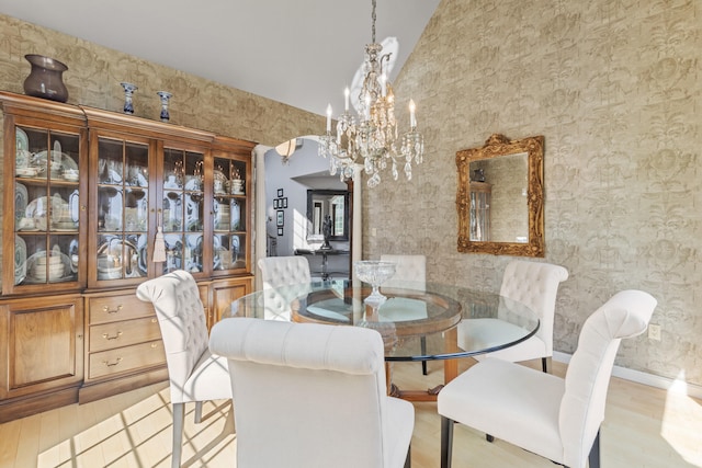33 Lakeview Ln, Harrison, ME 04040 - dining space with a chandelier, wood finished floors, vaulted ceiling, arched walkways, and wallpapered walls
