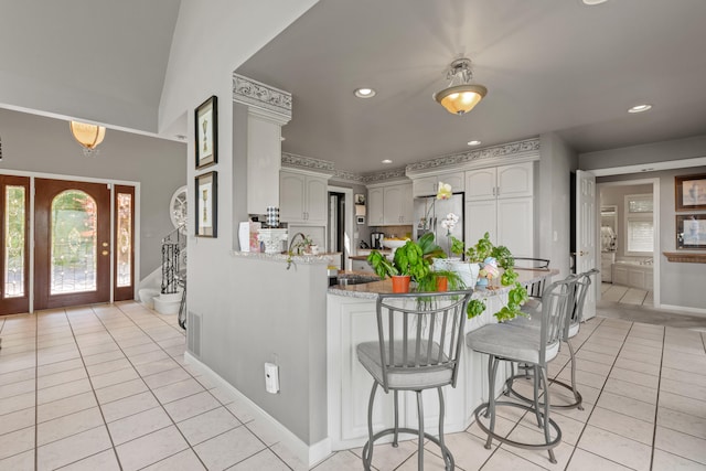 33 Lakeview Ln, Harrison, ME 04040 - kitchen featuring light tile patterned floors, a peninsula, stainless steel fridge with ice dispenser, recessed lighting, and light stone counters