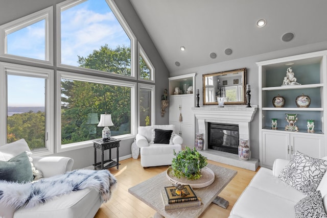 33 Lakeview Ln, Harrison, ME 04040 - living room featuring a glass covered fireplace, lofted ceiling, wood finished floors, and recessed lighting