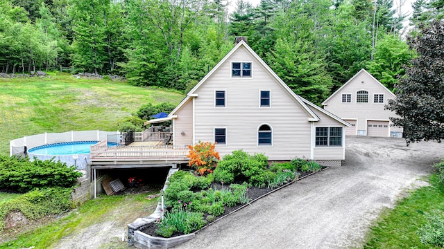 370 Center Conway Rd, Brownfield, ME 04010 - view of front of house with a wooden deck, a detached garage, an outdoor pool, a front yard, and a forest view
