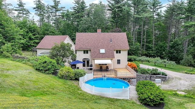 370 Center Conway Rd, Brownfield, ME 04010 - back of house with a wooden deck, an outdoor pool, a lawn, and a chimney