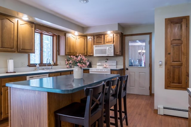 9 Kennebec Cir, Bath, ME 04530 - kitchen with white appliances, baseboard heating, a kitchen bar, a center island, and brown cabinetry