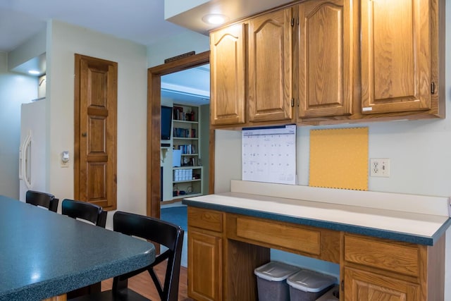 9 Kennebec Cir, Bath, ME 04530 - kitchen with freestanding refrigerator, light countertops, a kitchen breakfast bar, and brown cabinetry