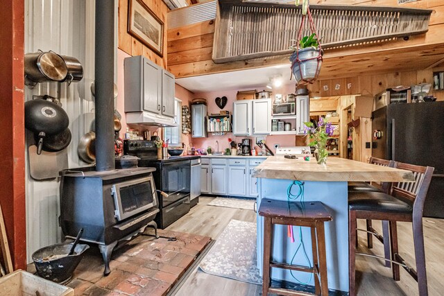 41 Dundee Rd, Albany Twp, ME 04217 - kitchen featuring appliances with stainless steel finishes, open shelves, butcher block counters, a breakfast bar, and light wood-style floors