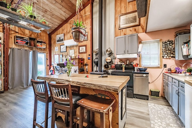 41 Dundee Rd, Albany Twp, ME 04217 - kitchen featuring vaulted ceiling, healthy amount of natural light, light wood finished floors, wood walls, and a kitchen bar