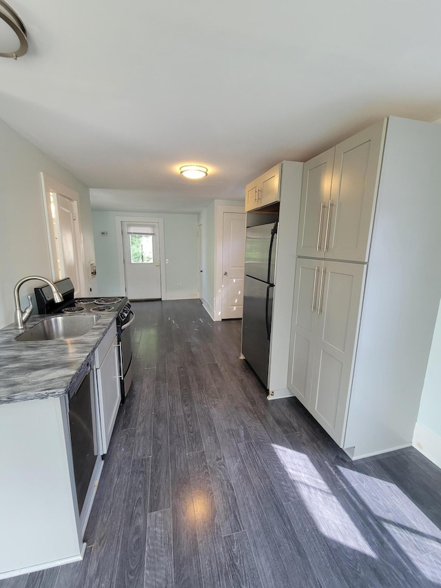 59 Washington St, Biddeford, ME 04005 - kitchen featuring stainless steel refrigerator, dark wood finished floors, range with electric stovetop, and white cabinetry