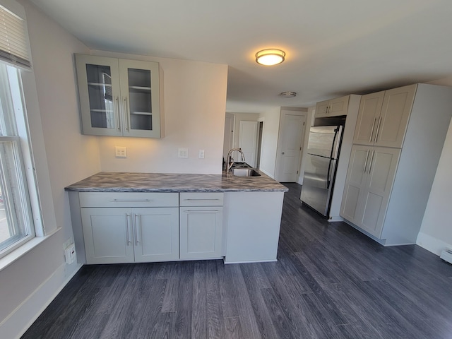 59 Washington St, Biddeford, ME 04005 - kitchen with freestanding refrigerator, dark wood-style floors, a peninsula, and glass insert cabinets