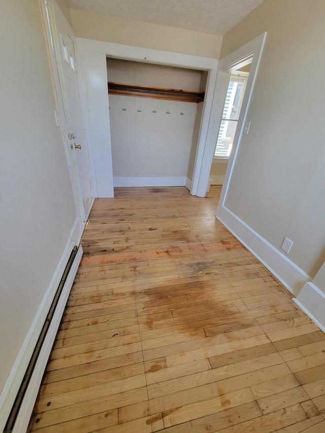 59 Washington St, Biddeford, ME 04005 - hallway featuring baseboard heating and light wood finished floors