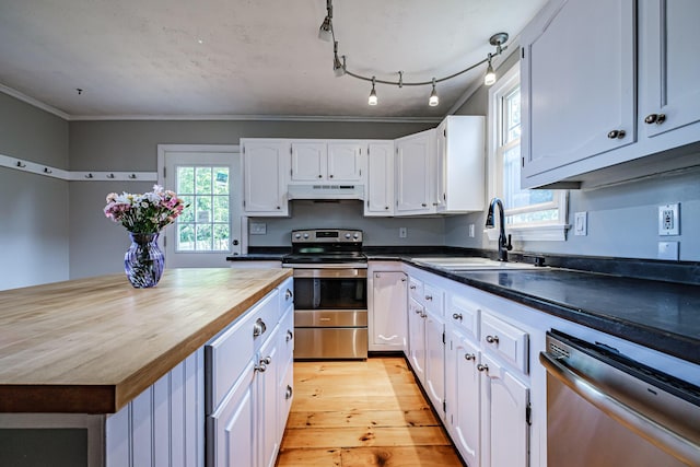 52 Mckinley St, South Portland, ME 04106 - kitchen featuring stainless steel appliances, under cabinet range hood, wooden counters, white cabinetry, and crown molding