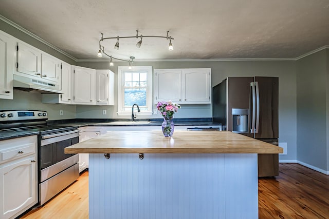 52 Mckinley St, South Portland, ME 04106 - kitchen featuring stainless steel appliances, under cabinet range hood, butcher block countertops, white cabinets, and light wood finished floors