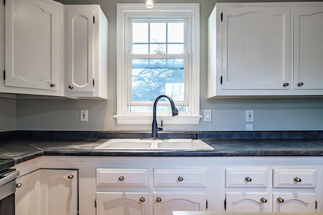 52 Mckinley St, South Portland, ME 04106 - kitchen featuring dark countertops, white cabinetry, and stainless steel stove