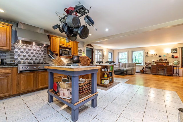 37 Paul St, York, ME 03909 - kitchen featuring wall chimney exhaust hood, appliances with stainless steel finishes, light tile patterned floors, open shelves, and open floor plan
