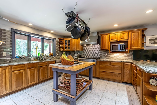 37 Paul St, York, ME 03909 - kitchen with open shelves, appliances with stainless steel finishes, brown cabinets, wall chimney range hood, and tasteful backsplash