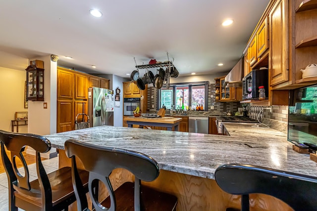 37 Paul St, York, ME 03909 - kitchen featuring stainless steel appliances, open shelves, a peninsula, a kitchen bar, and decorative backsplash