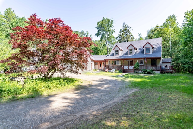 37 Paul St, York, ME 03909 - cape cod house with dirt driveway, covered porch, a front lawn, and a garage