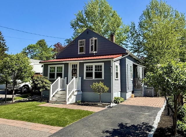 82 Park Ave, Old Orchard Beach, ME 04064 - view of front facade featuring a front lawn, a chimney, and a metal roof