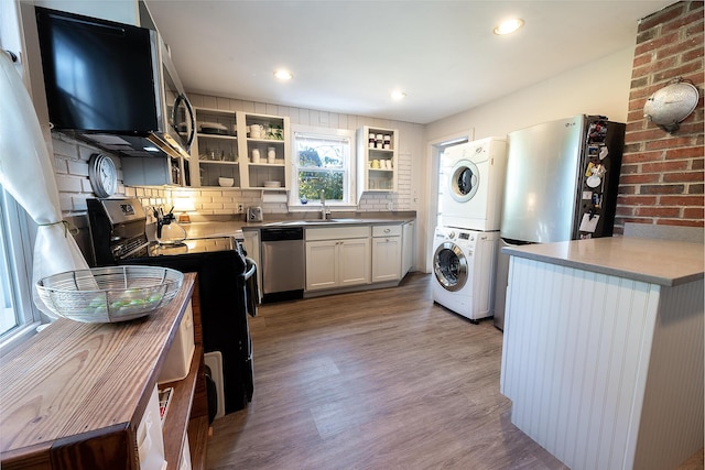 82 Park Ave, Old Orchard Beach, ME 04064 - kitchen with stacked washing machine and dryer, appliances with stainless steel finishes, light wood-style flooring, open shelves, and backsplash