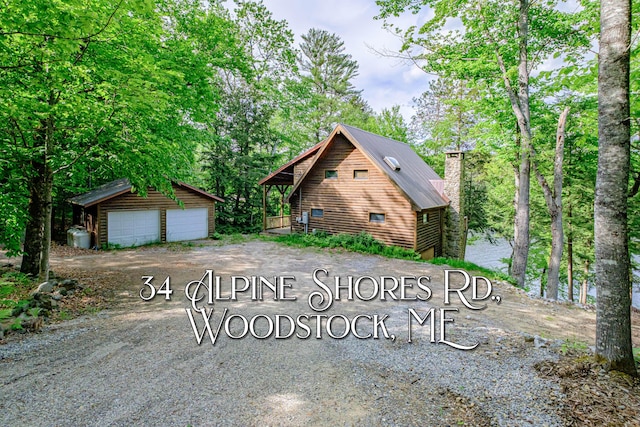 34 Alpine Shores Rd, Woodstock, ME 04219 - view of front of property with a detached garage, an outdoor structure, a chimney, and a metal roof
