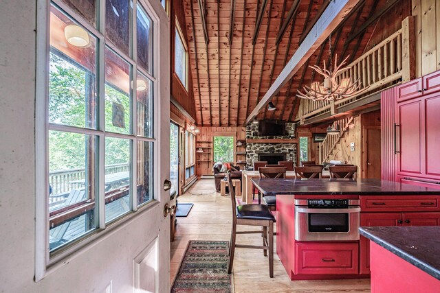 34 Alpine Shores Rd, Woodstock, ME 04219 - kitchen with stainless steel oven, dark countertops, plenty of natural light, light wood-type flooring, and wood ceiling