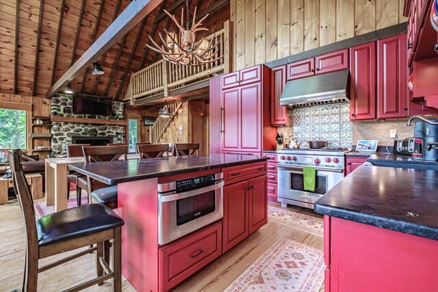 34 Alpine Shores Rd, Woodstock, ME 04219 - kitchen with premium stove, under cabinet range hood, reddish brown cabinets, dark countertops, and a wood ceiling with exposed beams