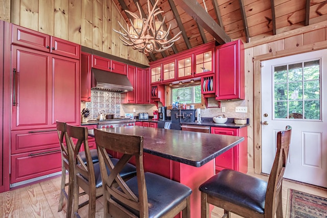 34 Alpine Shores Rd, Woodstock, ME 04219 - kitchen with extractor fan, a chandelier, dark countertops, reddish brown cabinets, and wooden walls