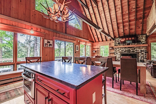 34 Alpine Shores Rd, Woodstock, ME 04219 - kitchen with dark countertops, high vaulted ceiling, light wood-style flooring, wood walls, and a wooden ceiling with exposed beams