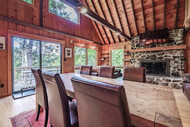 34 Alpine Shores Rd, Woodstock, ME 04219 - dining area featuring wood walls, high vaulted ceiling, hardwood / wood-style flooring, a wood ceiling with exposed beams, and a fireplace
