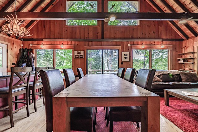 34 Alpine Shores Rd, Woodstock, ME 04219 - dining room featuring a wooden ceiling with exposed beams, wooden walls, light wood-style floors, high vaulted ceiling, and a chandelier