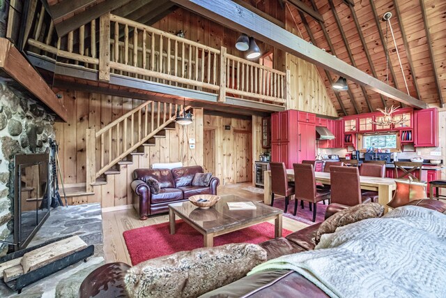 34 Alpine Shores Rd, Woodstock, ME 04219 - living area featuring stairs, high vaulted ceiling, light wood-style flooring, wood walls, and a fireplace