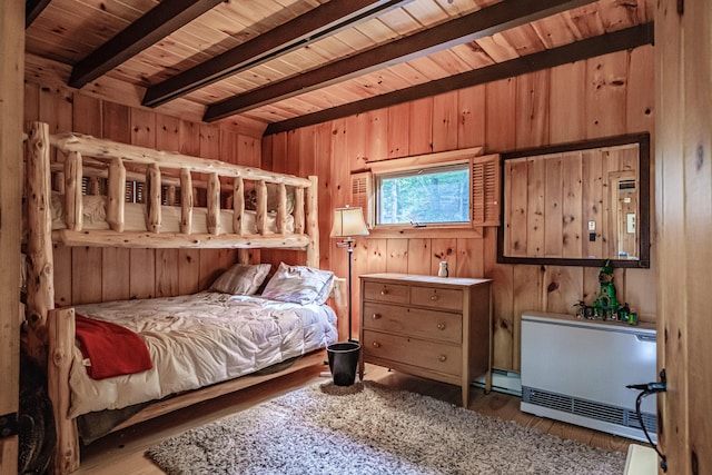 34 Alpine Shores Rd, Woodstock, ME 04219 - bedroom with wood finished floors, wood walls, a wooden ceiling with exposed beams, and a baseboard radiator