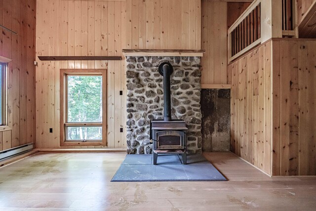 34 Alpine Shores Rd, Woodstock, ME 04219 - unfurnished living room featuring wooden walls, a wood stove, wood finished floors, and a towering ceiling