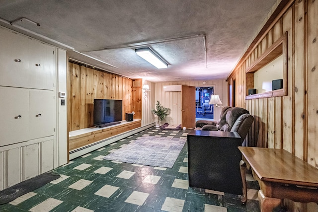 11 Dana Ave, Auburn, ME 04210 - living area featuring tile patterned floors, wood walls, a baseboard heating unit, and a textured ceiling