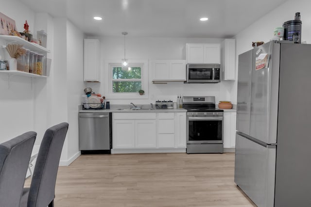 62 Seventh St, Auburn, ME 04210 - kitchen with stainless steel appliances, white cabinets, light wood-style flooring, recessed lighting, and light countertops