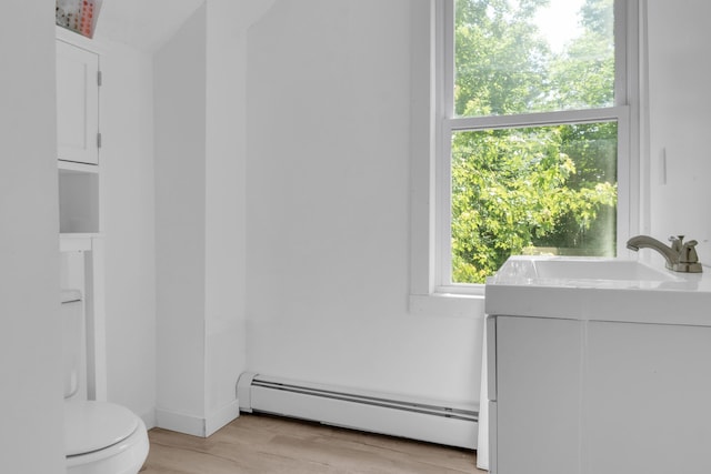 62 Seventh St, Auburn, ME 04210 - bathroom featuring a baseboard heating unit and wood finished floors
