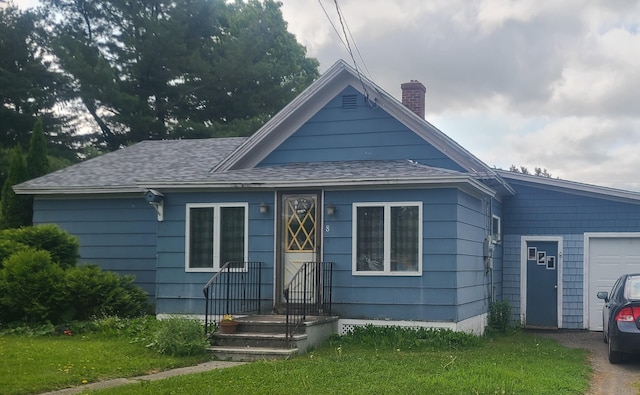 8 Maynard St, Washburn, ME 04786 - view of front of property with a chimney, a front yard, a shingled roof, and an attached garage