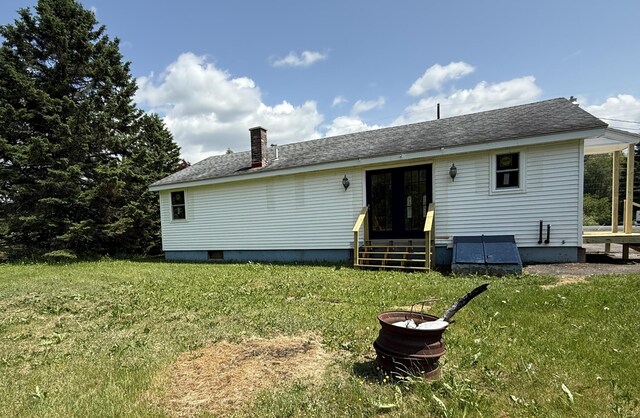 788 Access Hwy, Caribou, ME 04736 - rear view of property featuring entry steps, a lawn, a shingled roof, and a chimney