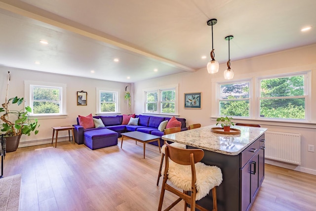 221 Lincolnville Ave, Belfast, ME 04915 - kitchen with light wood-style flooring, light stone counters, a kitchen island, a kitchen bar, and hanging light fixtures