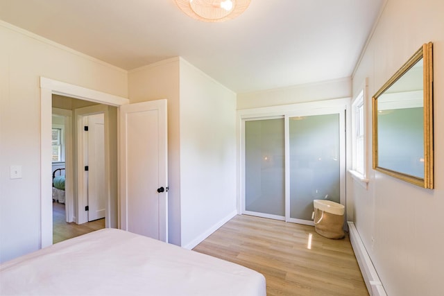 221 Lincolnville Ave, Belfast, ME 04915 - bedroom featuring light wood-type flooring, ornamental molding, baseboard heating, and a closet