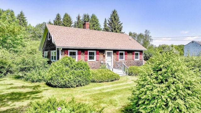 221 Lincolnville Ave, Belfast, ME 04915 - cape cod house featuring a chimney, a front yard, roof with shingles, and stone siding