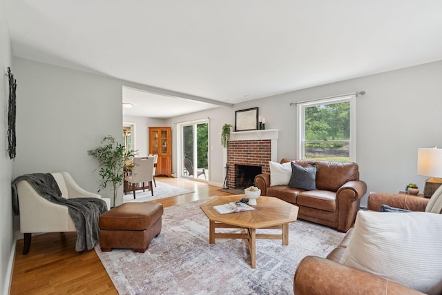 27 Libby Ln, Brunswick, ME 04011 - living room featuring healthy amount of natural light, light wood-style flooring, and a brick fireplace