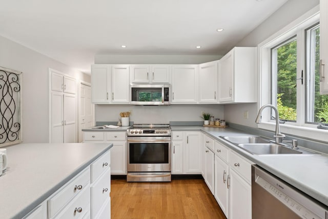 27 Libby Ln, Brunswick, ME 04011 - kitchen with stainless steel appliances, recessed lighting, white cabinetry, light countertops, and light wood-type flooring