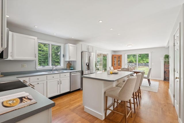 27 Libby Ln, Brunswick, ME 04011 - kitchen featuring stainless steel appliances, a breakfast bar area, white cabinets, light wood-style flooring, and recessed lighting