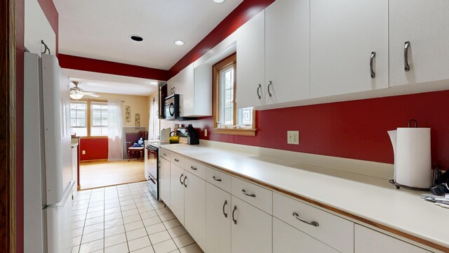 5 Wilson St, Lewiston, ME 04240 - kitchen with range, freestanding refrigerator, light countertops, white cabinets, and light tile patterned flooring